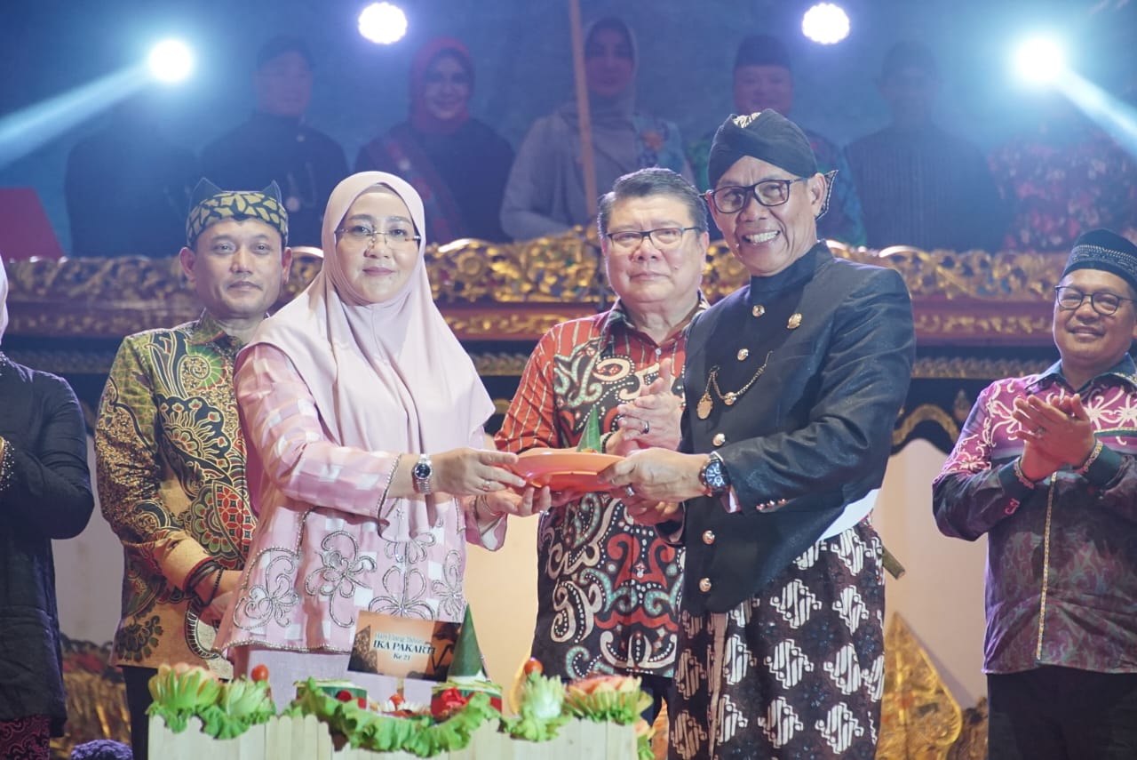 Bupati Berau Sri Juniarsih (kiri) menyerahkan potongan tumpeng ke Rusmadi Wongso.